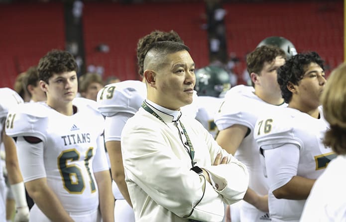 Blessed Trinity theology teacher Father Augustine Tran, center, stands among the players as Coach Tim McFarlin and the team captains accept the state runner-up trophy. Photo By Michael Alexander