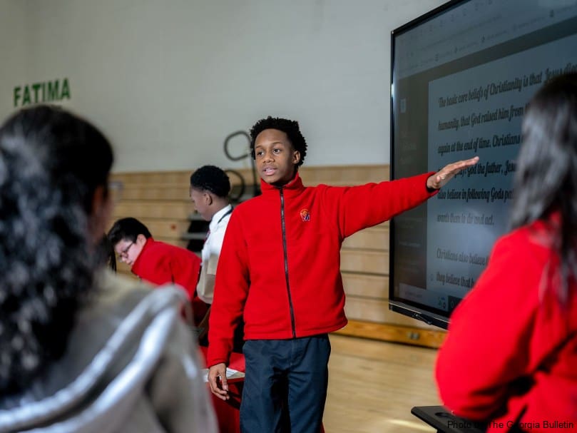 A St. Mary's Academy student explains world religions as part of a display during the STEM Showcase, which featured projects ranging from 3D printing to coding. Photo by Johnathon Kelso
