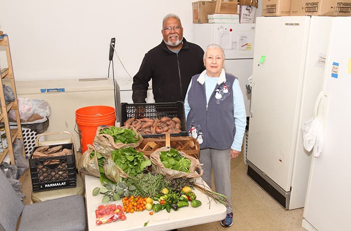Columbus Brown, left, drops off 60 pounds of vegetables and herbs from the Stone Mountain Community Garden to Stone Mountain Cooperative Ecumenical Ministry food pantry manager Nadalie Goldstein on Nov. 14. Photo By Michael Alexander