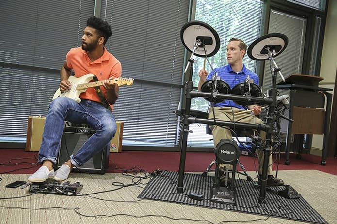 Jarrett Goodly, left, playing lead guitar, and Brendan Dudley, playing the electric drums, accompany recording artist Michael Tolcher as he performs during a summer concert for employees at the Archdiocese of Atlanta’s Chancery in Smyrna. Goodly, a senior at Georgia State University, has played guitar for nearly 9 years. Dudley, the Respect Life Ministry’s director, has played drums for 17 years. Photo By Michael Alexander