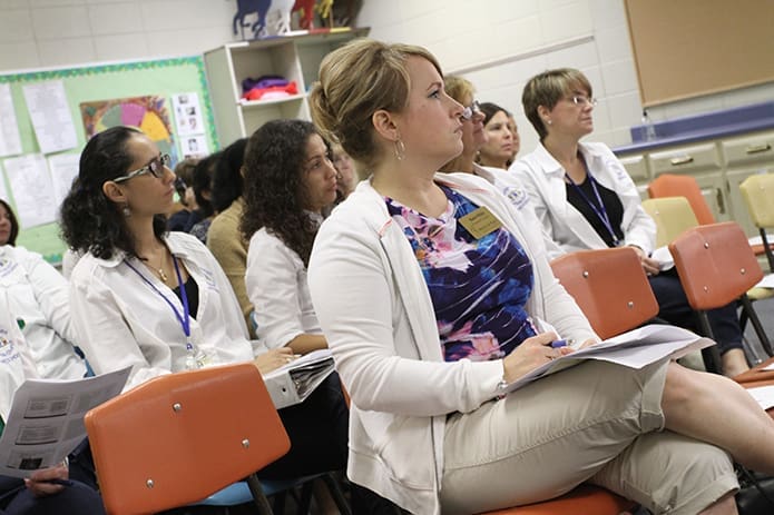 Marie White, foreground, a preschool teacher at Prince of Peace Church, Flowery Branch, joins a host of other preschool teachers in a morning workshop surrounding the 10 best reasons for rambunctious play by students. The workshop presenter was Frances Carlson, lead Early Childhood instructor at Chattahoochee Technical College. Photo By Michael Alexander