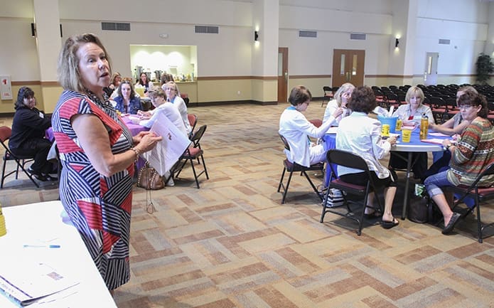 Workshop facilitator Ceci McAuliffe, standing left, gives some instructions just before the preschool directors begin an activity during their workshop. Photo By Michael Alexander