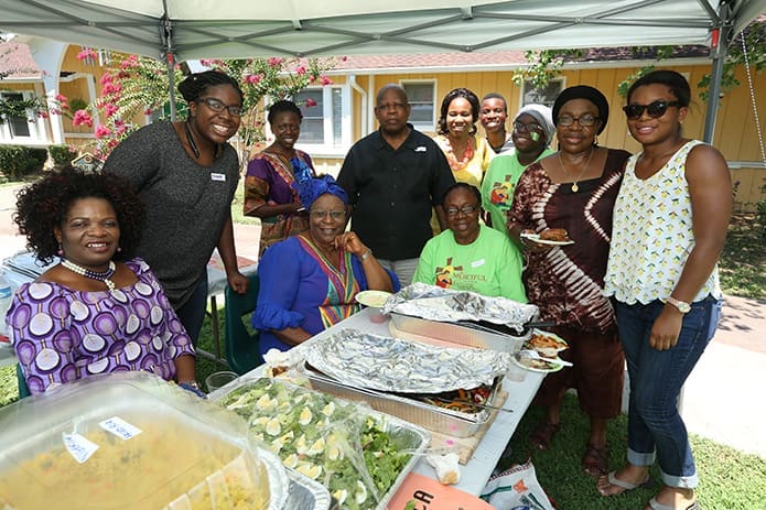 Members of St. John Vianney Church, Lithia Springs, stand under the Africa tent during the parish’s Taste of St. John Vianney Church. Those in the photograph are of Nigerian or Cameroonian descent. Photo By Michael Alexander