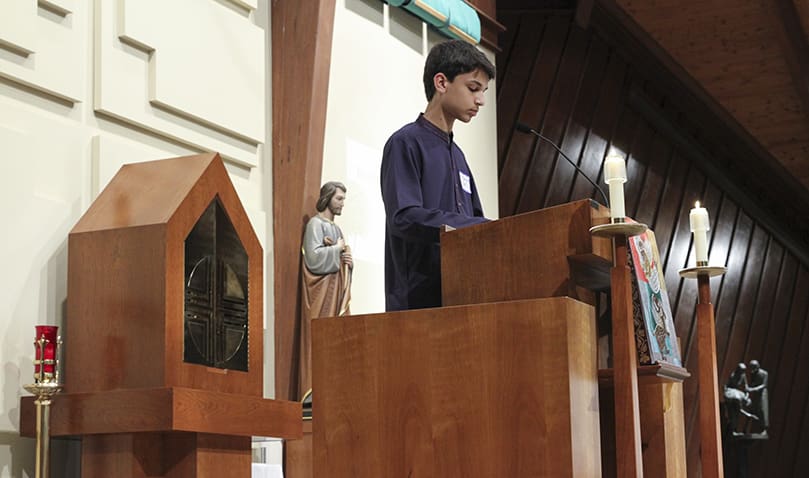 Ali Mohammed Rashid, 13, a member of the Sunday school program at the Islamic Center of North Fulton, leads the congregation in a moment of intercessory prayer. The Islamic Center’s Imam, Hafiz Asad Khan, also did a reading from the Quran in Arabic during the service. Photo By Michael Alexander