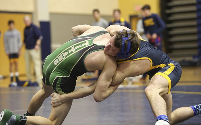 Two bodies with one head provides an interesting visual as Blessed Trinity's Noah Kile, left, and Marist School's Reed Bethune wrestle in last year's Catholic Duals. Photo By Michael Alexander