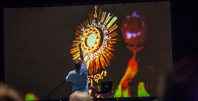 Speaker Doug Tooke gestures in front of an image of the Blessed Sacrament during the middle school track on Saturday, June 17. Photo by Thomas Spink