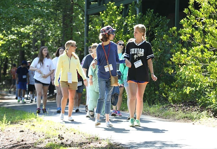 Maggie Pierson, right, a 16-year-old camp volunteer from St. Joseph Church, Marietta, walks with her camper Deborah Schulz to the groupâs next morning activity. Photo By Michael Alexander