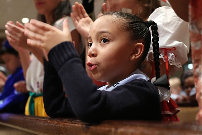 Alyn Baudy, a kindergarten student at St. John the Evangelist School joins fellow students during the opening song of the special liturgy that welcomed representatives from the University of Notre Dameâs Alliance for Catholic Education (ACE), Feb. 26. Photo By Michael Alexander