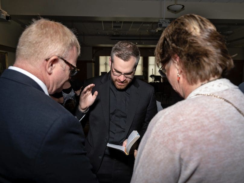 Deacon Evan Glowzinski offers a prayer of blessing over friends on the day of his ordination to the transitional diaconate at the Cathedral of Christ the King. Photo by Johnathon Kelso