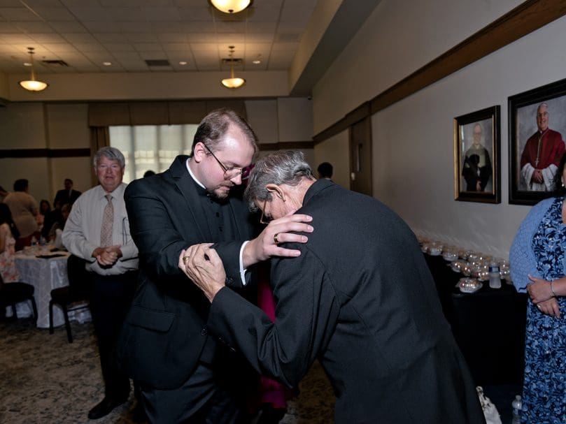 Deacon Matthew Howard blesses a priest following his May 21 ordination to the transitional diaconate. Deacon Howard will serve at St. Jude the Apostle before being ordained a priest next year. Photo by Johnathon Kelso