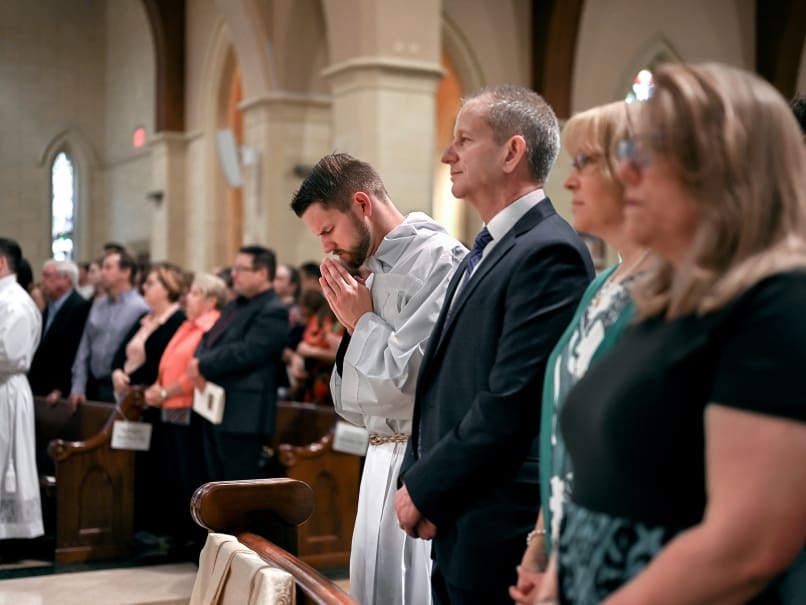 David DesPres stands with his family during the opening hymn of the Mass of ordination to the transitional diaconate at St. Peter Chanel Church. Photo by Johnathon Kelso