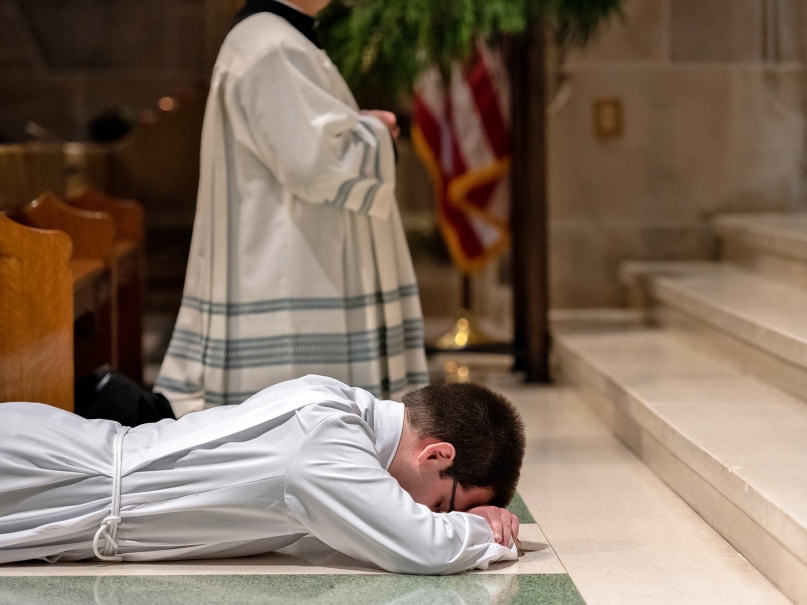 Pete Coppola lies prostrate at the altar during the Litany of Supplication at his Dec. 8 ordination as a transitional deacon. Photo by Johnathon Kelso