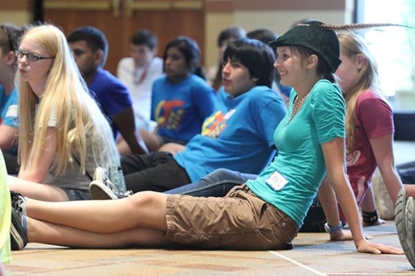 Fifteen-year-old April Freeman, wearing the hat, of St. Clement’s Church, Calhoun, listens to the World Youth Day Rally speaker with other youth from eight different parishes from around the Archdiocese of Atlanta. Photo By Michael Alexander