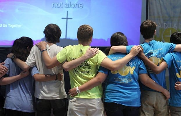 During a period of praise and worship, youth at the World Youth Day Rally in the parish hall of Holy Family Church, Marietta, come together in unity with the millions of youth participating in World Youth Day in Rio de Janeiro, Brazil. Photo By Michael Alexander
