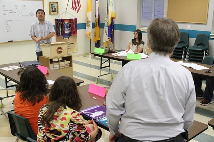YAM Toastmasters Club member William Brust, standing at the podium, uates the speech given by John Baker, standing foreground. Brust is a member of St. Peter Chanel Church, Roswell and Baker is a member of St. Brigid Church, Johns Creek. Photo By Michael Alexander