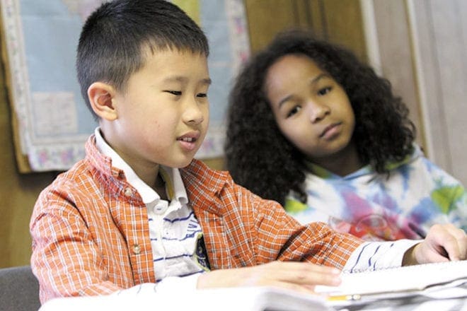Photo: Kevin Nguyen, 9, practices reading a sentence in Vietnamese during the May 4 cultural enrichment class, as Gia-An Maynard, 8, looks on.