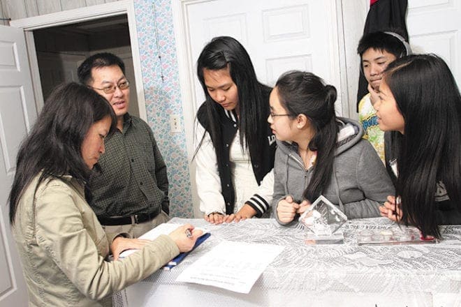 (L-r) Good Shepherd Services office manager Xuan Nguyen and volunteer teen cultural enrichment instructor Nghia Nguyen discuss some ideas with teens Lillian Long, Kelly Nguyen, Dawson Truong, and Lucille Long.