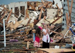 Two girls stand in rubble after a tornado struck Moore, Okla., May 20. The mile-wide tornado touched down near Oklahoma City, killing dozens, including many children, destroying homes, businesses and a pair of elementary schools in the suburb of Moore.