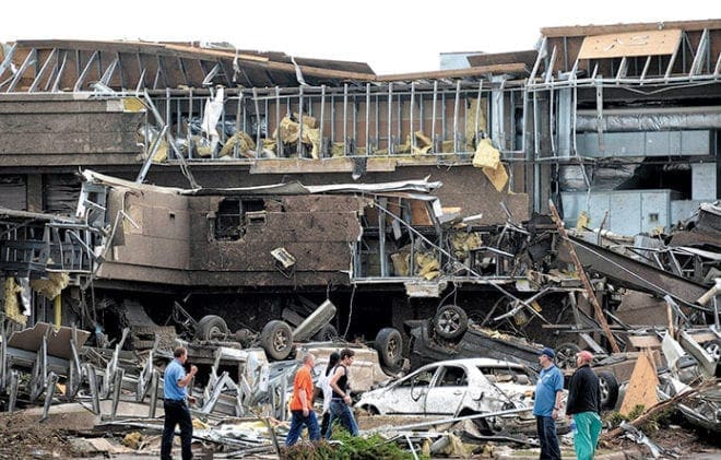 People survey the destruction at the hospital in Moore, Okla., after it was hit by a tornado that destroyed buildings and overturned cars in the town May 20. 