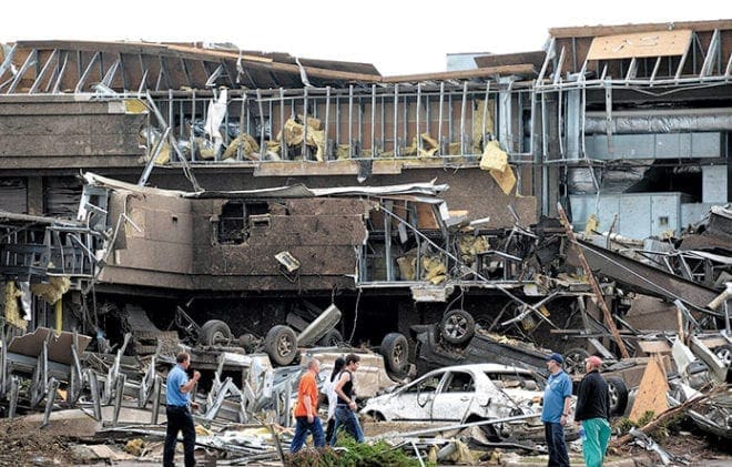 People survey the destruction at the hospital in Moore, Okla., after it was hit by a tornado that destroyed buildings and overturned cars in the town May 20.