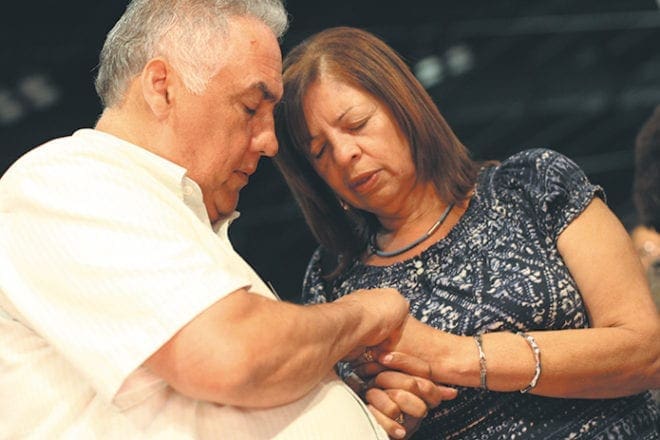 Luis and Gloria Burgos of St. John Neumann Church, Lilburn, pray together during the healing service that followed the opening Mass.
