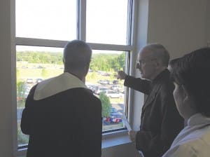 Father David McGuinness, on right, shares details about the Athens parish property with Bishop Luis R. Zarama. 