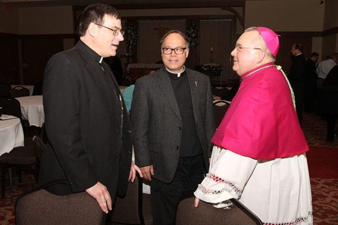 During a reception following the solemn vespers, Bishop-designate David Talley chats with two classmates from St. Meinrad Seminary, St. Meinrad, Ind., Father Thomas Schliessmann of the Archdiocese of Indianapolis, left, and Father Gregory Spencer of the Diocese of Raleigh.