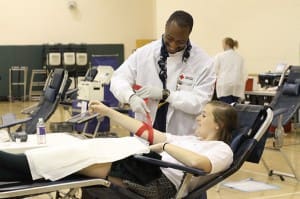 After donating a pint of blood Blessed Trinity High School junior Savannah Grace is assisted by American Red Cross blood collection tech Lorenzo Holmes during the school's Jan. 25 blood drive. Grace was a first-time donor. (Photos By Michael Alexander) 
