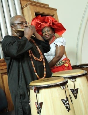 Dr. Infeyani Anikpe, left, of St. Paul of the Cross Church, Atlanta, blows the horn during the Call to Worship. Looking on is Uche Chioke of St. Thomas the Apostle Church, Smyrna. (Photos By Michael Alexander) 