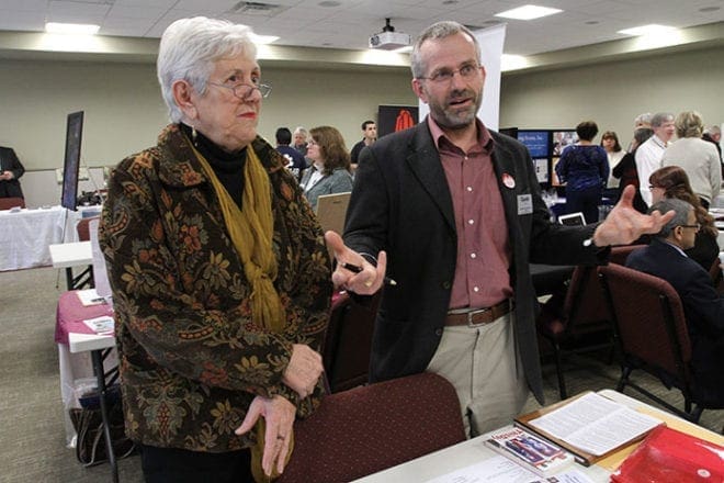 Jan Swanson of Interfaith Community Initiatives, left, and Gareth Young of Faith Alliance of Metro Atlanta speak with a Justice & Peace Exposition attendee. (Photo By Michael Alexander)