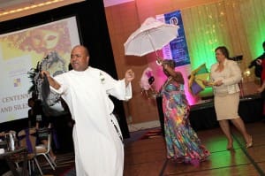 New Orleans native and Dominican Father Jeffery Ott, pastor of Our Lady of Lourdes Church, leads a second line procession around the dance floor during his parish’s centennial anniversary gala at the Atlanta Marriott Marquis Hotel.
