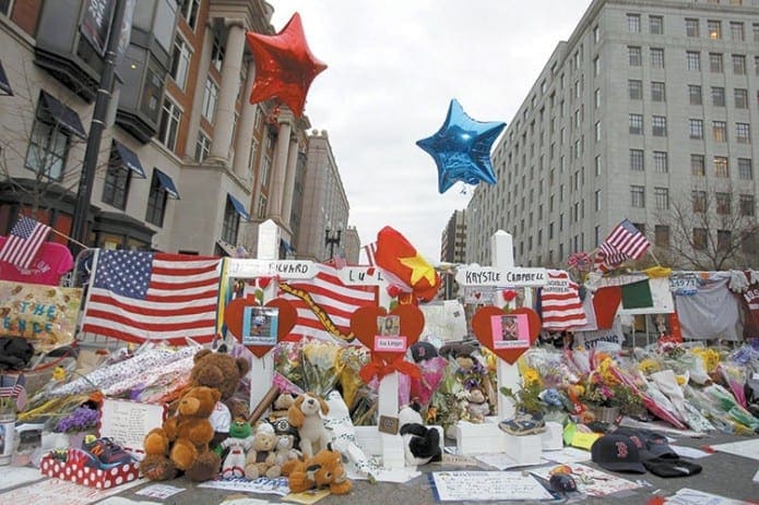 Three crosses for each of the three people killed in the Boston Marathon bombings are seen at a makeshift memorial on Boylston Street in Boston April 18. In celebrating the Good Shepherd Sunday Mass April 21 at the Cathedral of the Holy Cross, Boston Cardinal Sean P. O’Malley offered it for the repose of the souls of those killed in the bombings and the subsequent manhunt. Prayers also were said for those injured and for the first responders.