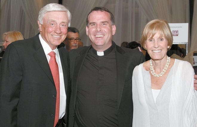 During the April 18 Catholic Charities Gala, Father Eric Hill, center, pastor of Prince of Peace Church, Flowery Branch, poses with some of his parishioners, former Atlanta Braves pitcher Phil Niekro and his wife, Nancy.