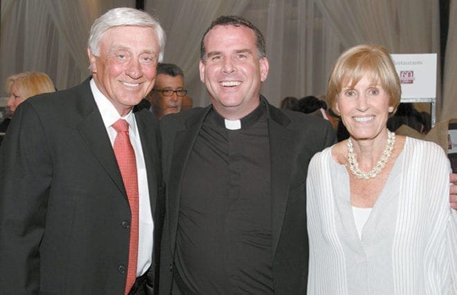During the April 18 Catholic Charities Gala, Father Eric Hill, center, pastor of Prince of Peace Church, Flowery Branch, poses with some of his parishioners, former Atlanta Braves pitcher Phil Niekro and his wife, Nancy. 