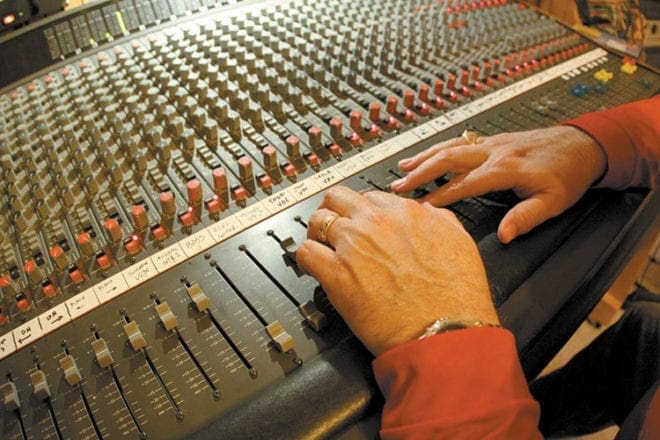 The fingers of Pat Phillips work the levers on the soundboard during a recording session at his home studio.