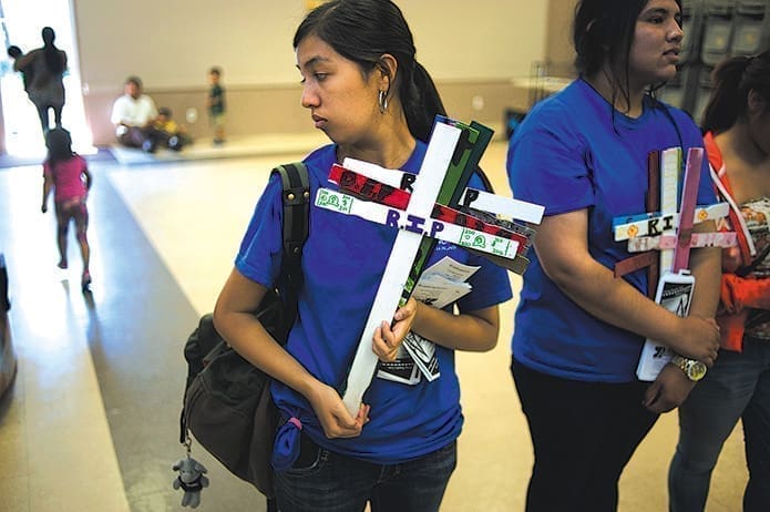 Activists with the immigration rights group Border Angels carry wooden crosses to a U.S. bishops’ news conference on immigration reform legislation June 10 at Our Lady of Guadalupe Church in San Diego. The wooden crosses represent undocumented workers who have died crossing into the United States.
