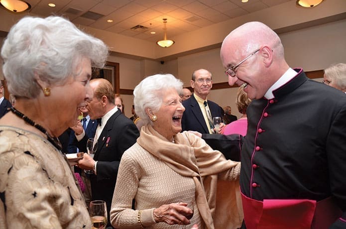 Msgr. Frank McNamee laughs along with friends who attended the Mass of Thanksgiving celebrated on April 17.