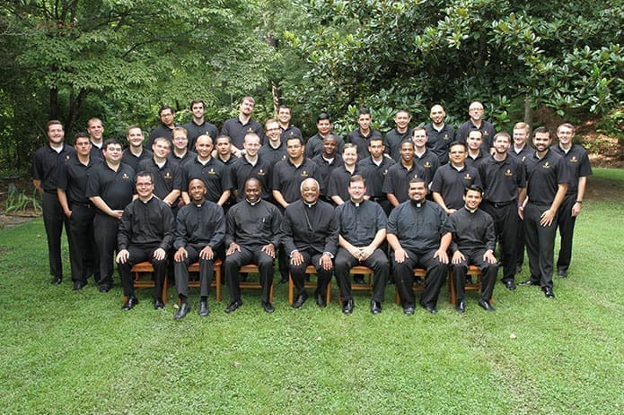 Archbishop Wilton D. Gregory, seated center, is joined by vocations director, Father Tim Hepburn, third from the right, and Archdioceses of Atlanta seminarians for an August 1 photo at Ignatius House Retreat Center. (Photo By Michael Alexander)