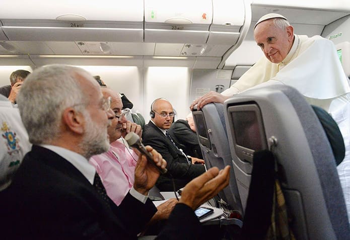 Pope Francis listens to a question from a journalist on his flight heading back to Rome July 29. The pope answered questions from 21 journalists over a period of 80 minutes on his return from Brazil.