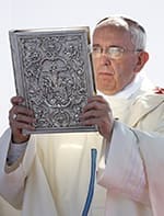Pope Francis raises the Book of the Gospels while celebrating Mass at the Sanctuary of Our Lady of Bonaria in Cagliari, Sardinia, Sept. 22.