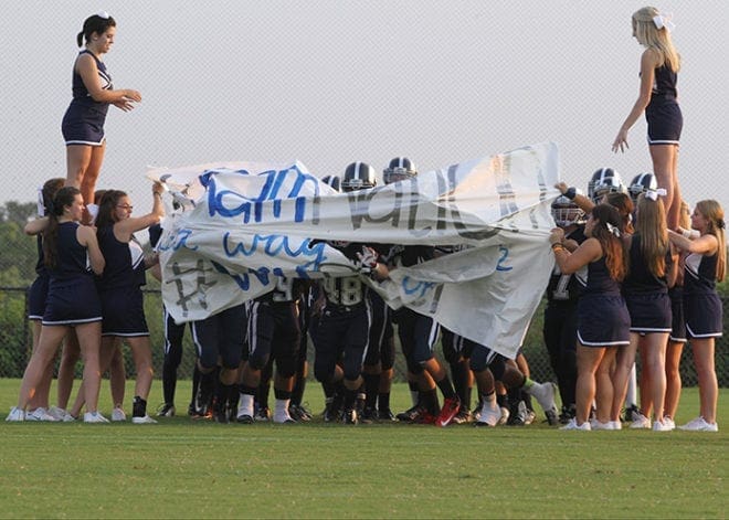 The team runs through the banner, held by cheerleaders, less than a minute before kickoff of the school’s inaugural regular season football game. The banner read “RAM NATION It’s a way of life.” 