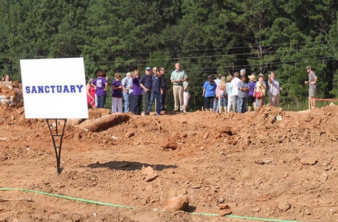 Father Daniel Toof leads a contingent of parishioners on a tour around the perimeter of the future church grounds, which is located at the corner of Monroe-Jersey Road and Criswell Road in Monroe. The proposed completion date is by the end of 2014. Photo By Michael Alexander