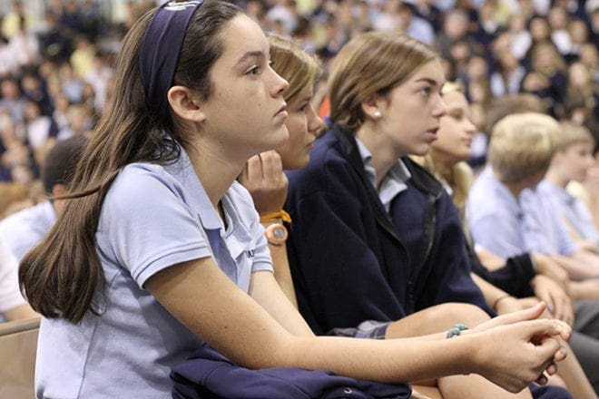 Marist School eighth-graders (l-r) Meg Fennelly, Mae Mae Utsch and Molly Sikes listen as Vietnam War survivor Kim Phuc Phan Thi shares her story during a school-wide assembly inside the Centennial Center, Oct. 22. Photo By Michael Alexander