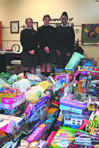 IHM students Annie Martin, Katherine Hally and Nina Burwell stand with some of the 599 toys collected for Catholic Charities Atlanta.