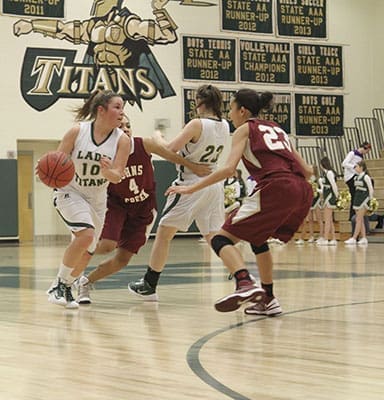 After Blessed Trinity High School’s Ellen Schlich (#23 in white) sets a pick, Payton Fadem (#10) looks to beat Johns Creek High School defenders Isabella Tremble (#4) and Sydney Tanguilig (#23) on her drive toward the basket. In the Jan. 4 game, Blessed Trinity lost to Johns Creek 48-41. Photo By Michael Alexander