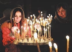 Women light candles during prayer service at a church in Kiev, Ukraine, Feb. 23. Ukraine's acting government issued a warrant Feb. 24 for the arrest of President Viktor Yanukovich, last reportedly seen in the pro-Russian Black Sea peninsula of Crimea, accusing him of mass crimes against protesters who stood up for months against his rule. CNS photo/David Mdzinarishvili, Reuters