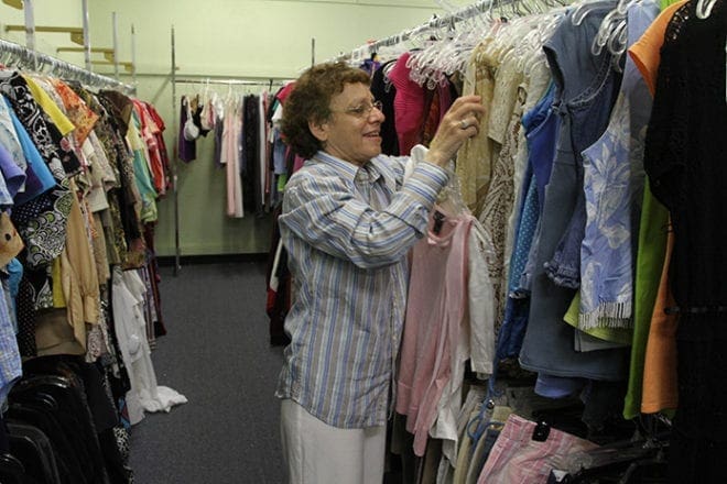 Lisa Malak, 60, hangs women’s clothing on the floor racks at the St. Vincent de Paul Second Time Around Thrift Store, Lilburn, where she has worked for five years. Malak also resides at St. Mary's independent living site in Tucker. Photo By Michael Alexander