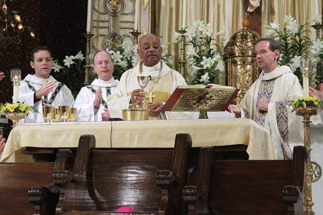 Archbishop Wilton D. Gregory, center, the main celebrant of the opening Mass of the National Association of Diaconate Directors' convention, and Bishop Michael F. Burbidge, Bishop of Raleigh, N.C., right, are joined around the altar by a number of clergy including (l-r) Father Greg Hammes, associate director of the Office of the Permanent Diaconate, Archdiocese of Kansas City, Kan., and Father W. Shawn McKnight, executive director of the USCCB’s Secretariat for Clergy, Consecrated Life and Vocations. Photo By Michael Alexander 