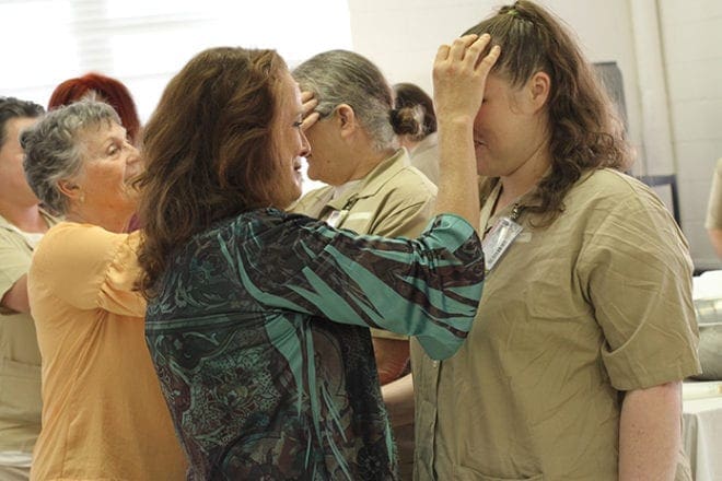 (Foreground to background) Catherine Boys of St. Thomas Aquinas Church, Alpharetta, marks the sign of the cross over the forehead of baptism candidate Felicia Nicole Greenway as Marge Pizzolato of St. Peter Chanel Church, Roswell, does the same for Carla Rae Hopwood. Photo By Michael Alexander