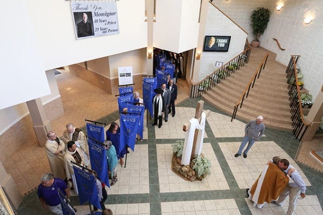 Banners line up in the Church of the Transfiguration narthex before the retirement Mass for Msgr. Patrick Bishop. He was the parish’s pastor for 25 years, so there was a banner for each year he served. Photo By Michael Alexander